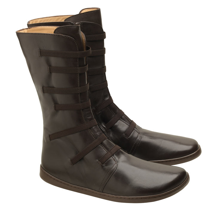 Die ATTRAQT Stretch Nappa Brown Stiefel von ZAQQ sind aus dunkelbraunem Ziegennappaleder gefertigt und verfügen über mehrere horizontale Riemen auf der Vorderseite und eine flache Sohle. Diese kniehohen Stiefel zeichnen sich durch ein schlankes Design mit leicht abgerundeten Zehen aus und bieten sowohl Stil als auch Flexibilität.