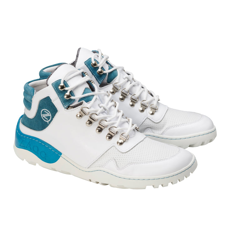 Wir präsentieren die wasserfesten VAQATION Turquoise Sneakers von ZAQQ, ein Paar weiße High-Top-Sneaker mit Akzenten in Blau- und Blaugrüntönen, silbernen Ösen und robusten weißen Sohlen, ideal für den entspannten VAQATION-Look. Das Markenlogo ist deutlich an der Seite und der Ferse zu sehen.