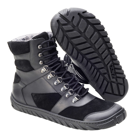 Ein Paar wasserdichte EXPLORER Black Sneakers von ZAQQ zeichnet sich durch eine robuste Sohle und ein Schnürdesign aus. Ein Sneaker steht aufrecht und hebt die Seitenansicht und die Schnürsenkel hervor, während der andere Schuh auf der Seite liegt und das strukturierte Sohlenmuster freigibt, das perfekt für Outdoor-Abenteuer ist.