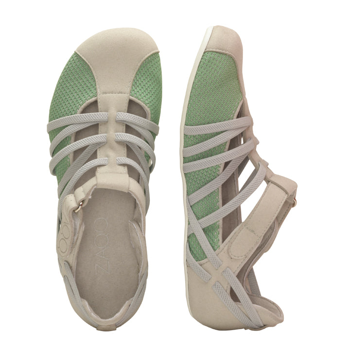 Ein Paar ZAQQ QLAIRE Green Sandalen mit überkreuzten Riemen und flacher Sohle in Grün und Beige. Die linke Sandale ist von oben zu sehen, während die rechte Sandale im Barfußschuh-Stil von der Seite zu sehen ist, um ihr offenes Design und das strukturierte Meshgewebe-Material hervorzuheben.