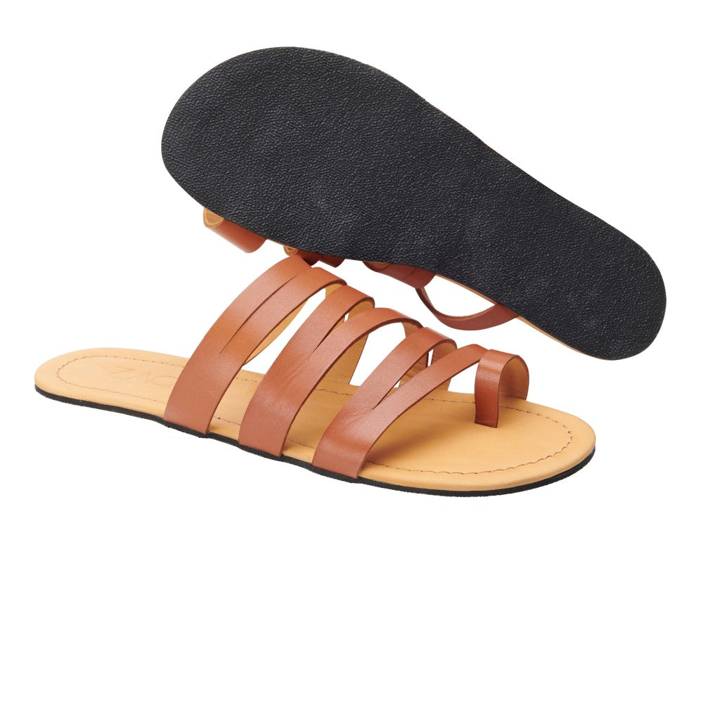 Die FLAQE Brown Sandalen von ZAQQ bestechen durch ihr minimalistisches Design mit mehreren Riemen. Eine Sandale zeigt ihre schwarze Sohle mit der Sohle nach oben, während die andere flach liegt und das hellbraune Fußbett hervorhebt.