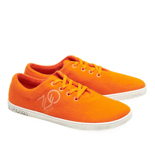 Wir präsentieren die LIQE Orange Sneaker von ZAQQ. Diese leuchtend orangefarbenen Schuhe mit weißen Akzenten und Sohlen bieten ein gemütliches Barfußgefühl. Sie werden mit passenden orangefarbenen Schnürsenkeln geliefert und tragen das ZAQQ-Logo an der Seite. Die Sneaker werden vor einem schlichten weißen Hintergrund präsentiert, wodurch ihr auffälliges Design wirklich hervorsticht.