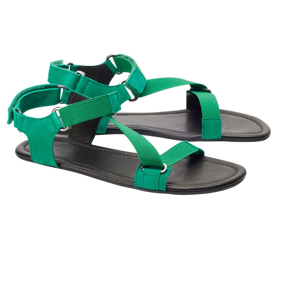 Ein Paar ZAQQ MIQA Grüne Sandalen mit verstellbaren Riemchensystem-Riemen und schwarzen Sohlen. Diese Sandalen haben Klettverschlüsse für einen sicheren Sitz, offene Zehen und ein minimalistisches Design, was sie ideal für lässige oder sommerliche Anlässe macht.