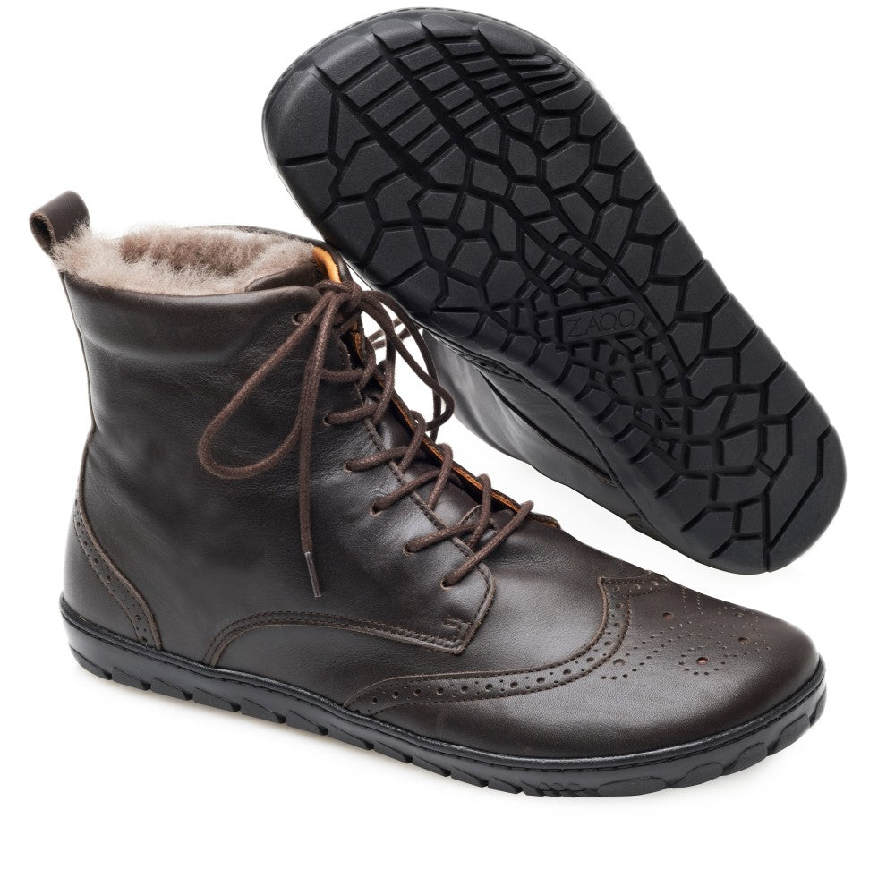 Wir präsentieren den QUINTIC Winter Brogue Dark Brown von ZAQQ: ein Paar stylische Lederstiefel aus hochwertigem Nappaleder. Diese dunkelbraunen Stiefel haben dekorative Nähte, Schnürsenkel und eine weiche Lammfell-Innenseite. Ein Stiefel ist aufrecht abgebildet, während der andere seine strukturierte schwarze Sohle zeigt, was sie perfekt für einen schicken Winter-Brogue-Look macht.