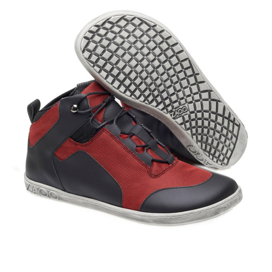 Wir präsentieren die RAQO Black Red High-Tops von ZAQQ. Dieser moderne vegane Sneaker zeichnet sich durch eine auffällige Kombination aus rotem Stoff und schwarzem lederähnlichem Material aus. Die Sohlen sind grau mit einem komplizierten strukturierten Gittermuster. Ein Schuh liegt auf der Seite, um die Sohle hervorzuheben, während der andere hoch steht, um sein stilvolles Design zu präsentieren.