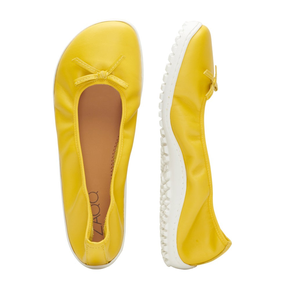 Abgebildet sind zwei SUQAR Lemon Ballerinas von ZAQQ, einer von oben und der andere von der Seite. Jeder Schuh hat vorne eine kleine Schleife. Die Schuhe haben weiße Sohlen mit strukturierten Griffen, die diesen stylischen Ballerinas eine praktische Note verleihen.