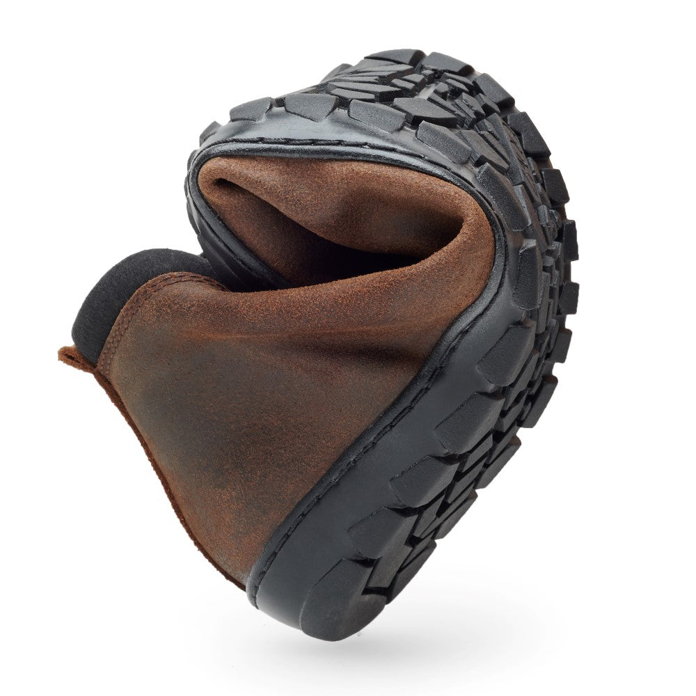 Der EXPEQ Mid Brown Waterproof Schuh von ZAQQ verfügt über eine schwarze strukturierte Sohle, die sich flexibel zu einer Kugel zusammenrollen lässt und so sein weiches und flexibles Design zur Geltung bringt. Das macht ihn perfekt für alle, die einen Outdoorschuh suchen.