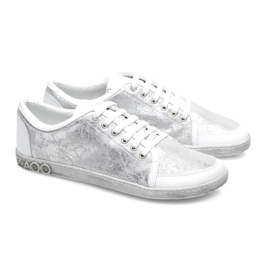 Wir präsentieren den TIQQ Silver White von ZAQQ: Ein Paar stylischer Sneaker aus hochwertigem Nappaleder mit einer auffälligen metallisch-silbernen Textur und weißen Sohlen. Diese Sneaker sind mit strahlend weißen Schnürsenkeln, Ziernähten und einem markanten 4000-Detail an der Seite der Sohle ausgestattet.